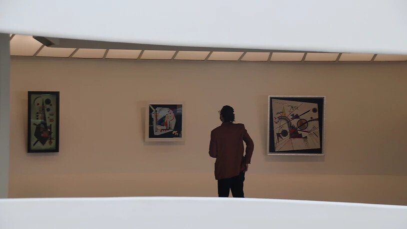 Eine Person betrachtet ein Werk von Wassily Kandinsky anlässlich einer Presse-Vorbesichtigung im New Yorker Guggenheim Museum. Seit Freitag zeigt das Guggenheim Museum in seiner berühmten Rotunde eine große Ausstellung mit Werken des russischen Künstlers…