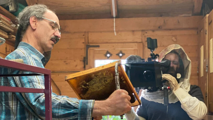 Geduldig: Stefan Manser erklärt dem Filmteam seine Arbeit im Bienenhaus.