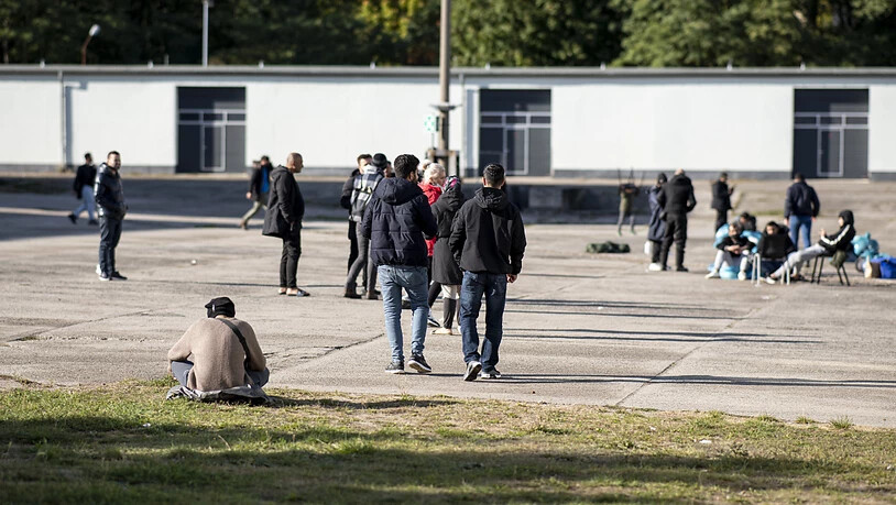 Asylsuchende laufen in der Erstaufnahmeeinrichtung Eisenhüttenstadt über einen Platz. Foto: Fabian Sommer/dpa