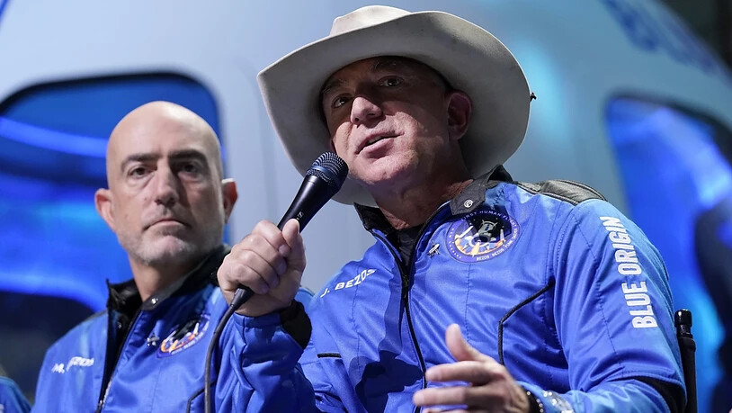 ARCHIV - Jeff Bezos (r), Gründer von Amazon und des Weltraumtourismus-Unternehmens Blue Origin, und sein Bruder Mark Bezos sprechen bei einer Pressekonferenz. Blue Origin plant eine eigene Station im All mit dem Namen «Orbital Reef». Das teilte die Firma…