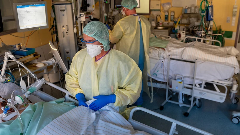 Eine Intensivpflegerin (vorne) versorgt einen schwer an Covid-19 erkrankten Patienten im Universitätsklinikum Halle/Saale. Foto: Hendrik Schmidt/dpa-Zentralbild/dpa