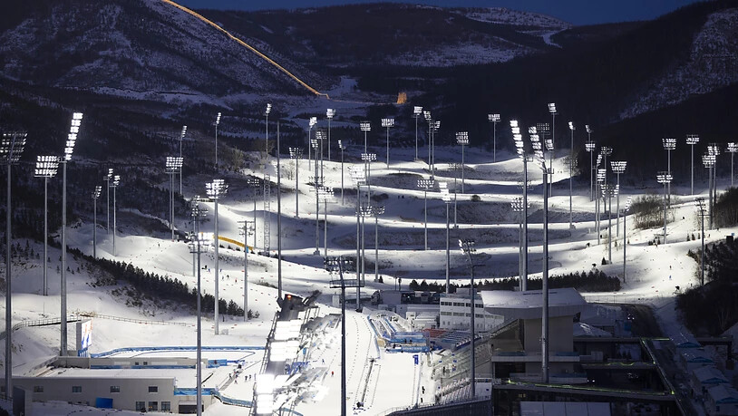 Die Biathlon-Arena in Zhangjiakou bei Nacht - links im Hintergrund die beleuchtete Chinesische Mauer