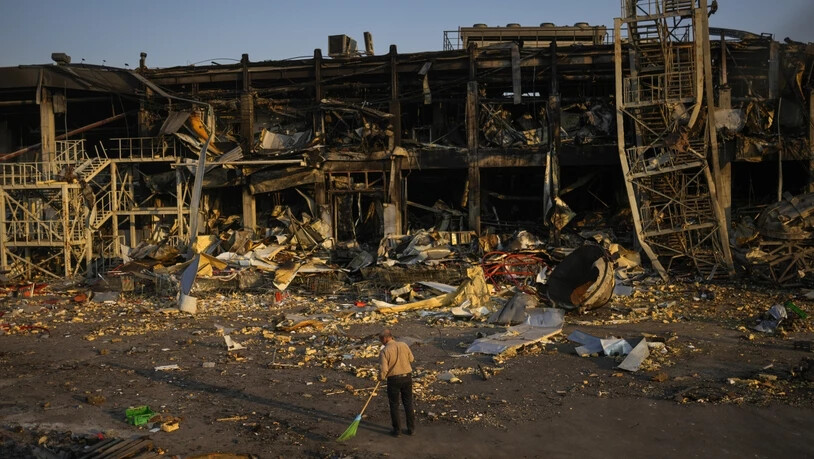 Ein Mann fegt in Odessa die Trümmer zusammen. Das Einkaufzentrum wurde am 9. Mai durch einen russischen Raketenangriff zerstört. Foto: Francisco Seco/AP/dpa