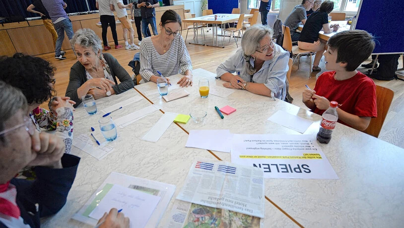 Spielerisch entwickeln: Davide Moro (rechts) erklärt in der Runde, welche Spiele er im Kartoni-Park spielen möchte. Er hat vorher auch schon am Akkordeon den Workshop musikalisch eingeleitet. 