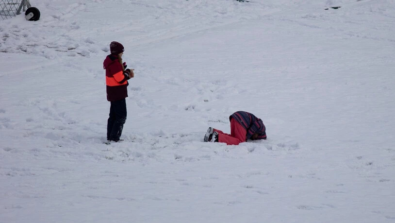 Schulkinder amüsieren sich im Schnee.