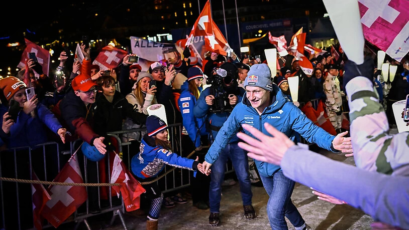 Marco Odermatt rennt zwischen den Schweizer Fans zur Siegerehrung