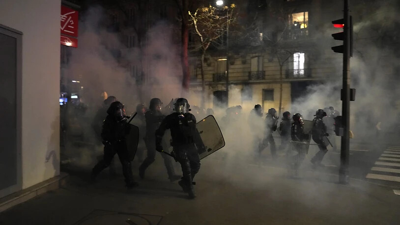 Polizisten rennen während einer Demonstration  gegen den Regierungsentscheid zur Rentenreform auf Demonstranten zu. Foto: Lewis Joly/AP