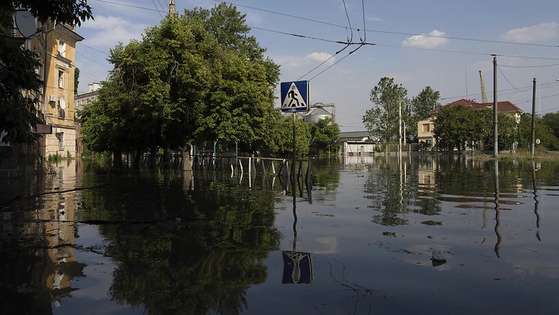 Eine überflutete Straße in Cherson. Der russische Angriffskrieg gegen die Ukraine ist durch die Sprengung des wichtigen Kachowka-Staudamms gefährlich eskaliert. Foto: Evgeniy Maloletka/AP/dpa