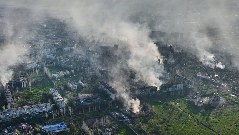 ARCHIV - Rauch steigt aus Gebäuden in Bachmut in der Region Donezk auf. Foto: Libkos/AP/dpa