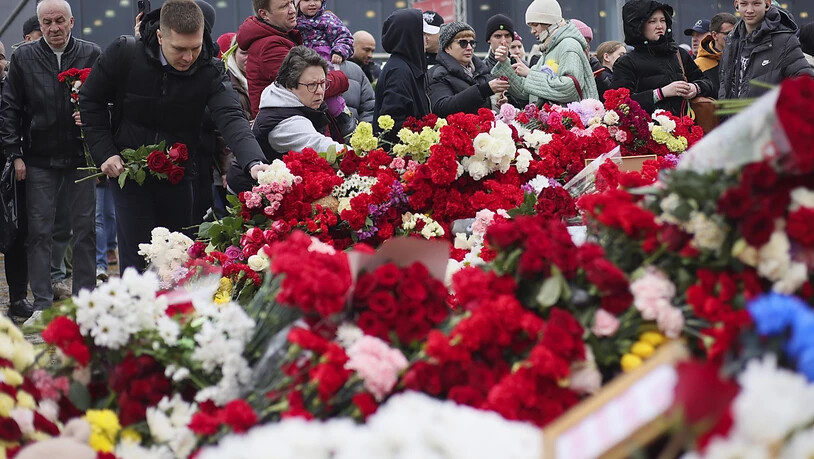 Menschen legen Blumen und Spielzeug am Ort des Anschlags ab. Foto: Vitaly Smolnikov/AP/dpa