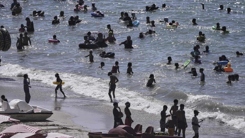 ARCHIV - Menschen verbringen Zeit am Strand in der Nähe der Stadt Alexandria. Foto: Amr Nabil/AP/dpa