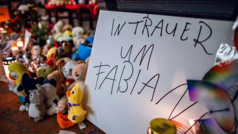 ARCHIV - Kerzen, Plüschtiere und ein Schild «In Trauer um Fabian» stehen vor dem Beginn des Trauergottesdienstes zum Abschied des achtjährigen Fabian am Eingang zur Marienkirche. Die Leiche des Kindes war am 14.10.2025, vier Tage nach seinem Verschwinden…