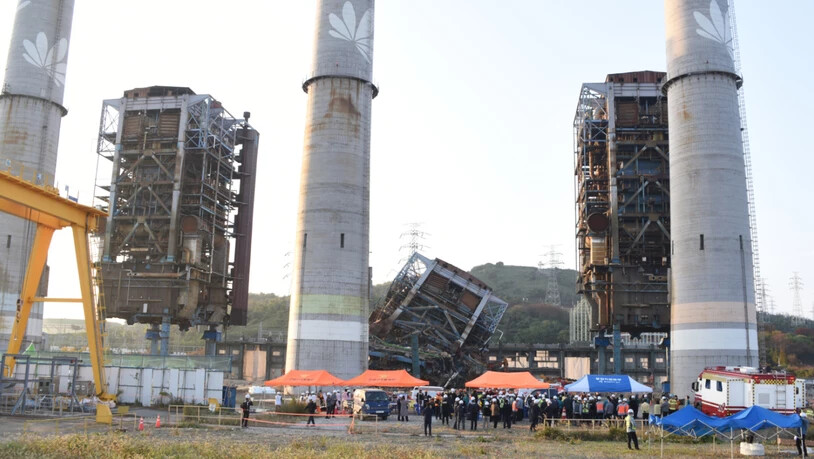 Ein Rettungsteam arbeitet in der Nähe eines 60 Meter hohen Turms, der bei Abbrucharbeiten in einem stillgelegten Wärmekraftwerk in Ulsan, Südkorea, zusammengebrochen ist. Foto: Uncredited/NEWSIS/dpa