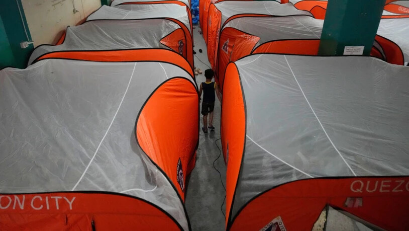 Ein Junge geht zwischen Zelten in einem Evakuierungszentrum umher, als der Taifun Fung-wong in Quezon City auf den Philippinen ins Land zieht. Foto: Aaron Favila/AP/dpa