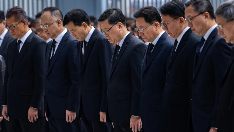 Hongkongs Regierungschef John Lee (Mitte) und führende Beamte der Sonderverwaltungszone legen eine Schweigeminute ein. Foto: Chan Long Hei/AP/dpa