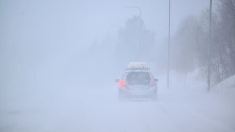 Ein Auto fährt bei Nebel durch eine Schneelandschaft. Sturm Johannes fegt durch Skandinavien. Foto: Pontus Lundahl/TT News Agency/AP/dpa