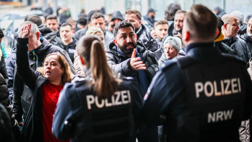 dpatopbilder - Aufgebrachte Kunden diskutieren vor der Sparkassenfiliale in Buer mit Polizeibeamten nach der Räumung des Vorraums der Filiale. Foto: Christoph Reichwein/dpa - ACHTUNG: Nur zur redaktionellen Verwendung im Zusammenhang mit der aktuellen…