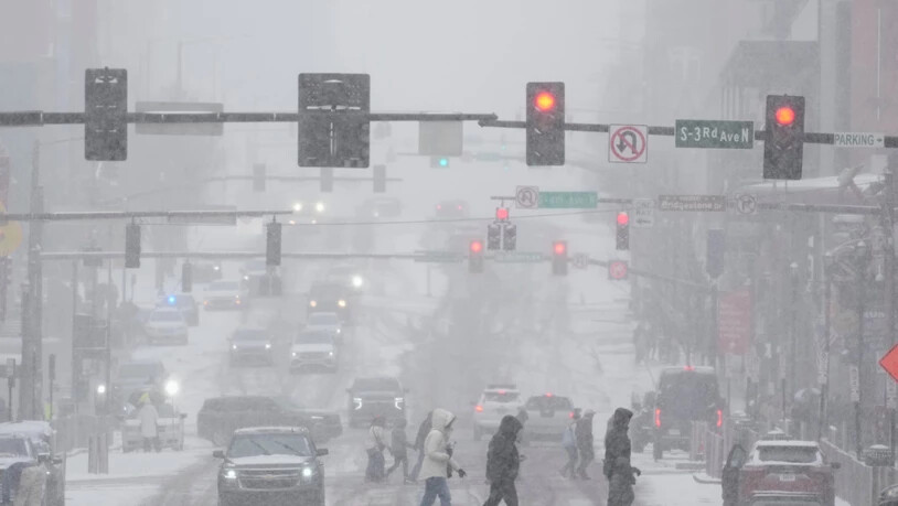 dpatopbilder - Fußgänger überqueren die Straße am Broadway während eines Wintersturms in Nashville. Foto: George Walker IV/AP/dpa