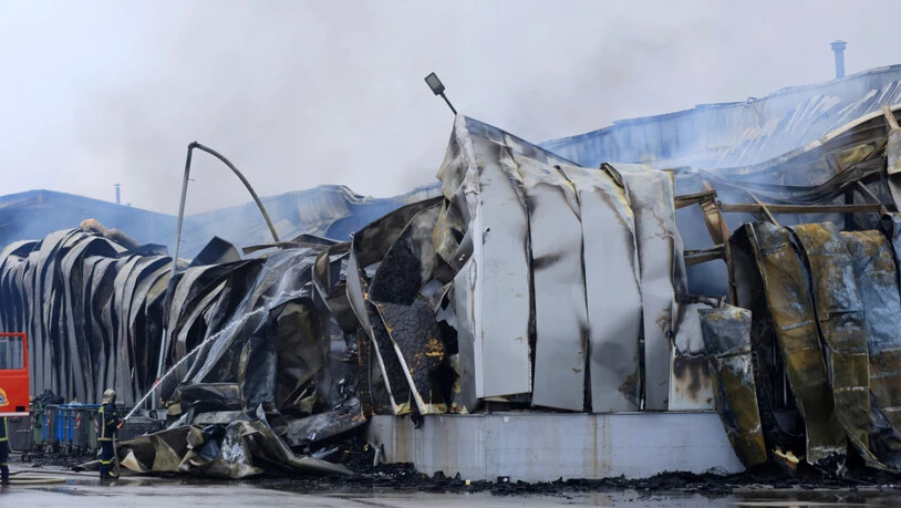 dpatopbilder - Ein Feuerwehrmann versprüht Wasser nach einer Explosion und einem Brand in einer Keksfabrik in Trikala. Foto: George Kidonas/InTime News/AP/dpa