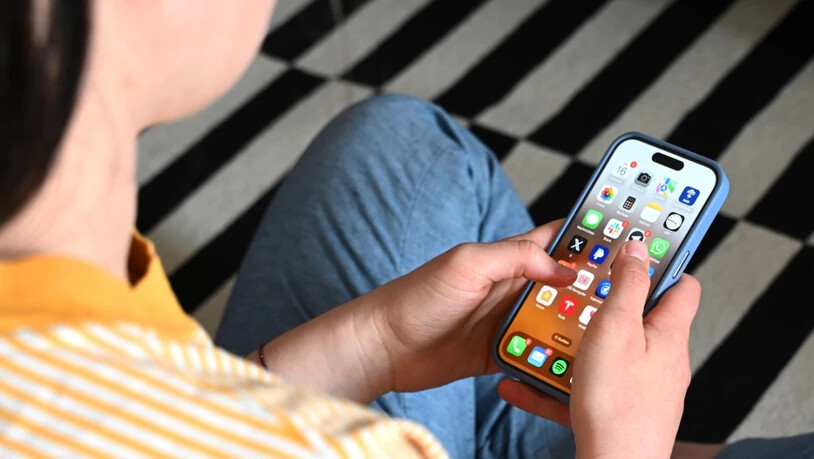 SYMBOLBILD - Eine Jugendliche sitzt auf dem Boden und nutzt ein Smartphone - auf dem Display sind verschiedene Apps zu sehen. Foto: Elisa Schu/dpa