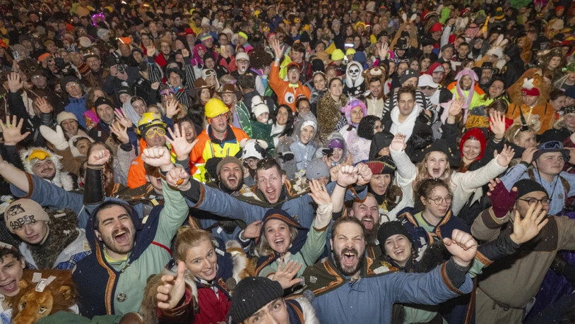 Fasnächtlerinnen und Fasnächtler geniessen den "Fötzeliräge" nach dem Urknall an der Fritschi-Tagwache der Luzerner Fasnacht.