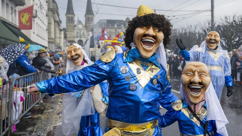 Eine Gruppe wilder Fasnachtskreaturen bei wechselhaftem Winterwetter am traditionellen Wey-Umzug in der Stadt Luzern.