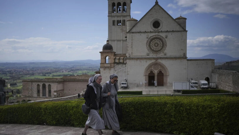 ARCHIV - Nonnen gehen an der päpstlichen Basilika und dem Kloster des Heiligen Franz von Assisi in Assisi vorbei. Foto: Alessandra Tarantino/AP/dpa