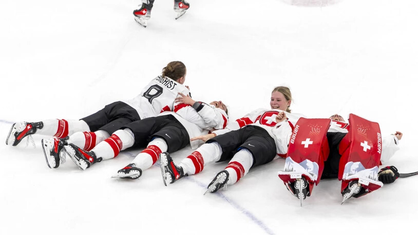 Die Schweizer Torhüterin Andrea Brändli (rechts) legt sich nach Spielschluss mit Teamkolleginnen aufs Eis