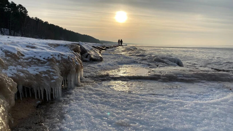 ARCHIV - Spaziergänger gehen am Strand der teilweise zugefrorenen Ostsee entlang. Foto: Alexander Welscher/dpa