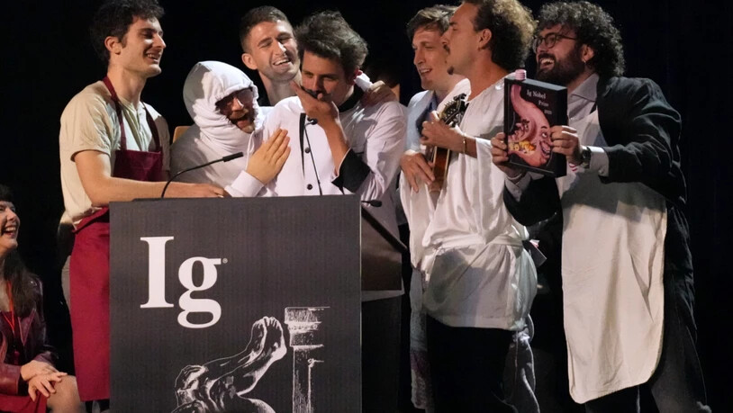 ARCHIV - Der Ig-Nobelpreis für Ernährung wird von Daniele Dendi, Gabriel H. Segniagbeto, Roger Meek und Luca Luiselli entgegengenommen, die untersucht haben, inwieweit eine bestimmte Eidechsenart bestimmte Sorten von Pizza isst. Foto: Robert F. Bukaty/AP…