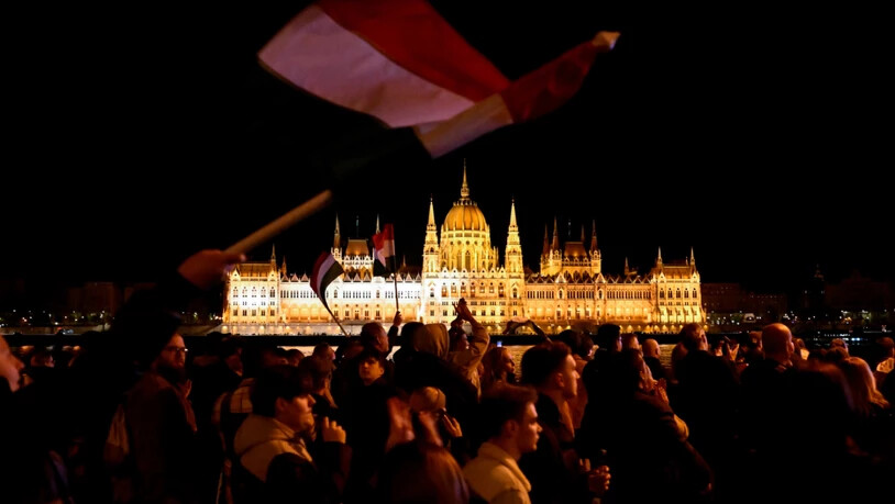 Menschen reagieren auf der Straße nach der Bekanntgabe der Teilergebnisse der ungarischen Parlamentswahlen. Foto: Denes Erdos/AP/dpa