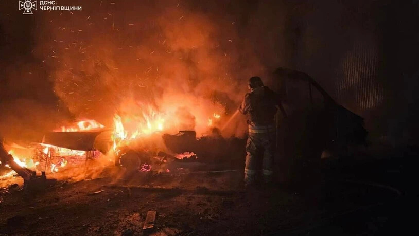 HANDOUT - Auf diesem vom ukrainischen Rettungsdienst via AP zur Verfügung gestellten Foto löscht ein Rettungshelfer das Feuer eines durch einen russischen Angriff zerstörten Autos. Foto: Ukrainian Emergency Service/Ukrainian Emergency Service/AP/dpa -…