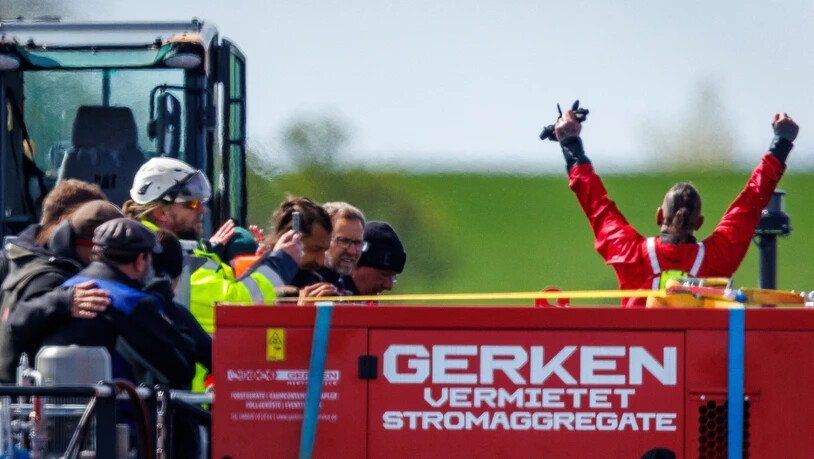 dpatopbilder - Helfer feiern auf dem Transportschiff, nachdem der gestrandete Buckelwal vor der Insel Poel mit Gurten in den Lastkahn gezogen wurde. Foto: Jens Büttner/dpa