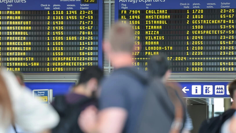 ARCHIV - Reisende warten vor der Anzeigentafel am Nürnberger Flughafen, die verspätete oder gestrichene Flüge anzeigt. Weltweite Probleme in den Computersystemen störten damals auch An - und Abflüge am Nürnberger Flughafen. Foto: Daniel Löb/dpa