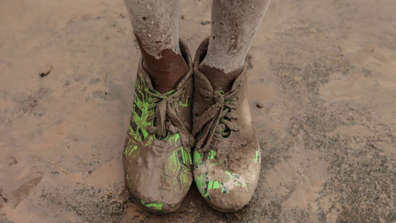 ARCHIV - Mit Vulkanasche verschmutzte Schuhe eines Jungen. Foto: Albert Ivan Damanik/ZUMA Wire/dpa/Archivbild