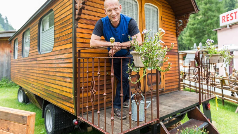 Ein Stück jenische Geschichte: Daniel Huber, Präsident der Radgenossenschaft der Landstrasse, steht auf dem Campingplatz Rania in Zillis vor dem historischen jenischen Wohnwagen (2017). 