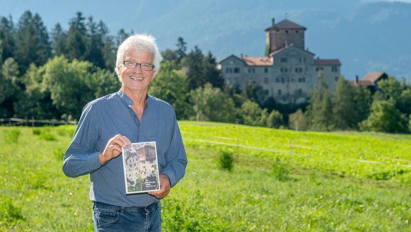 Andrea Hämmerle, Mitbesitzer des Schloss Rietberg in Pratval (im Hintergrund zu sehen). Er hält sein frisch gedrucktes Buch «Die Rietberger Saga» in Händen.

