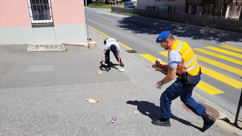 Hier wird keine Busse fällig: Die Littering-Patrouille der Securitas nimmt in Davos vom Gehweg Karton auf, der für die Abfallsammlung bereitgestellt war, aber vom Wind verstreut wurde.