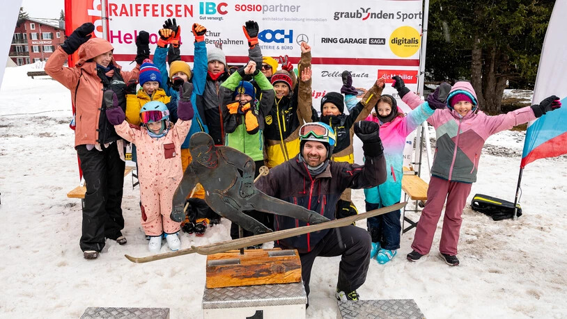 Strahlende Gesichter: Die Teilnehmenden jubeln, und im Vordergrund ist die Trophäe platziert.