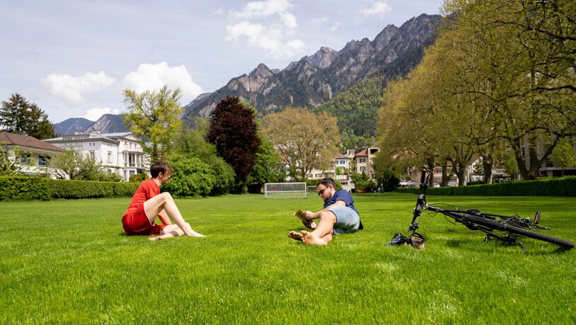 Frühlingsbeginn: Am Wochenende steigen die Temperaturen und die Menschen zieht es in die Natur. Zwei Freunde geniessen die Sonne auf der Turnerwiese in Chur.