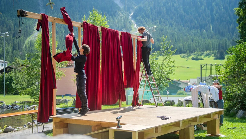 Aubauarbeiten in Bergün: Taddeo Dazzi (links) und Tim Lauer montieren den roten Samtvorhang der Origen-Commedia-Bühne.