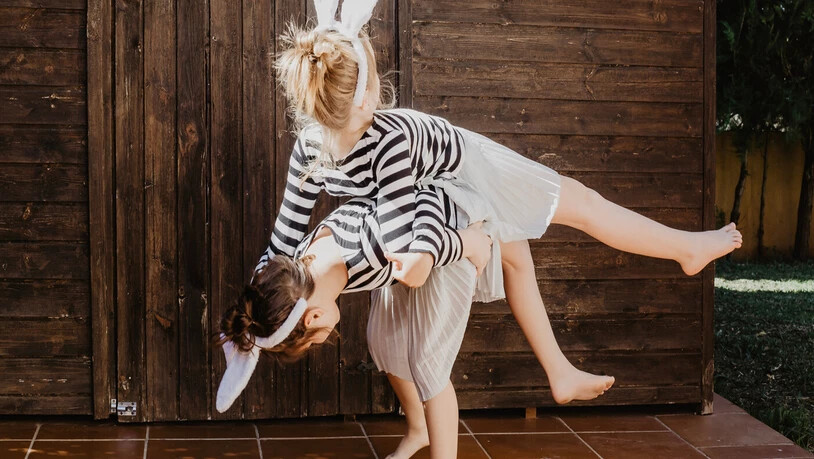 Mit Häschen-Ohren: Zwei Mädchen turnen im Garten herum.