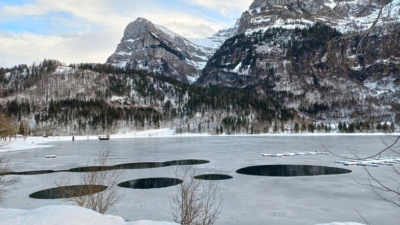 Es ist kein Morsecode: Eine Eisdecke bedeckt derzeit den Klöntalersee, aber beim Bootssteg weist die Eisschicht Löcher auf.