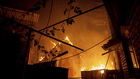 Ein Haus brennt nach einem Angriff in Cherson. Foto: Evgeniy Maloletka/AP/dpa