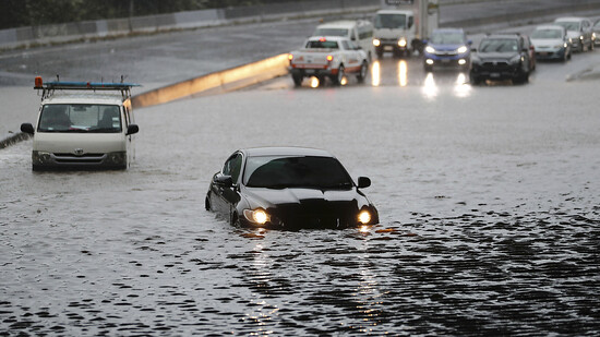 dpatopbilder - Fahrzeuge stehen am 26. Januar im Hochwasser einer überschwemmten Straße. Foto: Dean Purcell/New Zealand Herald/dpa
