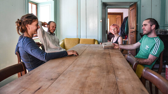 Fröhlich am Esszimmertisch: Piera Buchli, Luc Isenschmid, Clémence Stoll und David Isenschmid (von links) fühlen sich wohl in ihrem ungewöhnlichen Domizil in Versam.