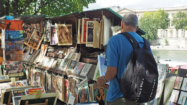 ARCHIV - Ein Mann schaut sich an einem der Bücherstände der Bouquinistes de Paris am Seineufer um. Foto: Rachel Boßmeyer/dpa