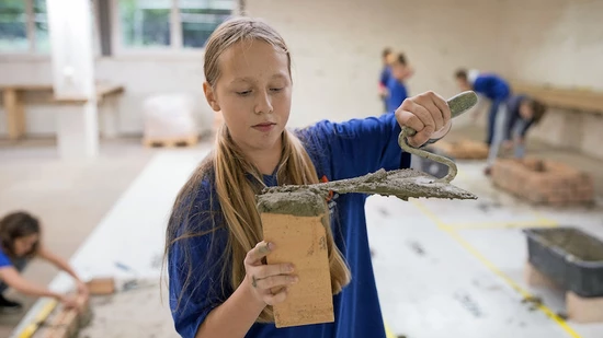 Nicht nur ein Männerberuf: Am Zukunftstag nehmen jeweils auch Mädchen die Maurerkelle in die Hand.