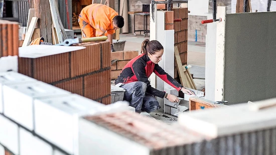 Französisch fällt weg, aber das Handwerk bleibt: Eine angehende Maurerin übt für die Lehrabschlussprüfung-der praktische Teil soll stattfinden.