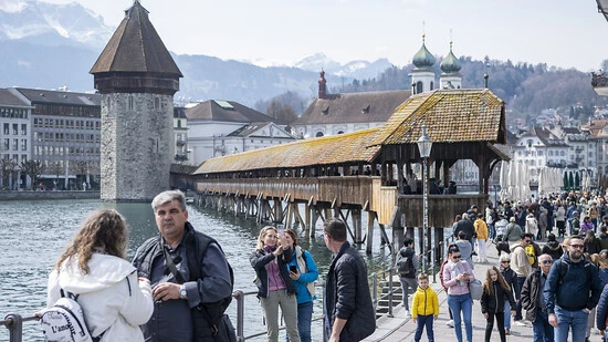Zahlreiche Tagestouristen geniessen einen Frühlingstag an der Reuss in der Altstadt von Luzern. (KEYSTONE/Urs Flueeler)